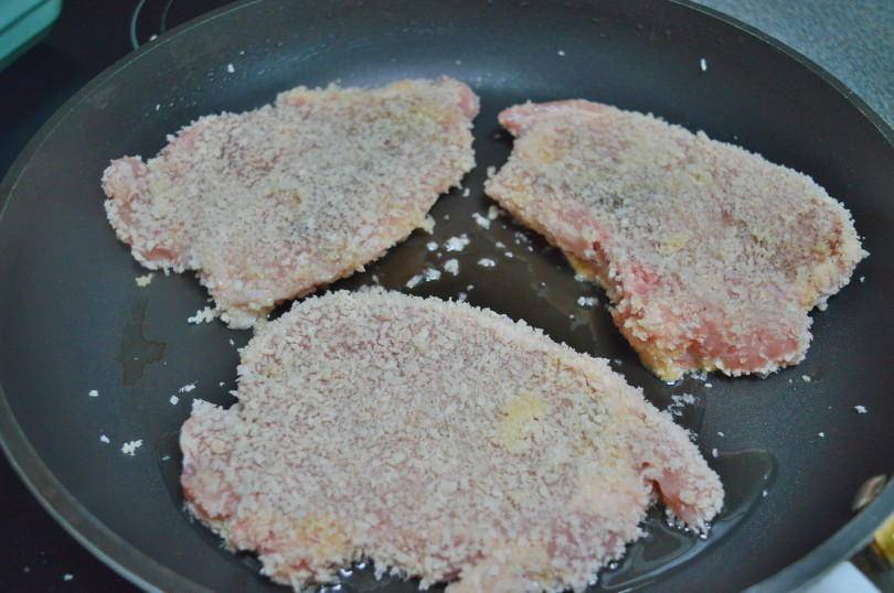 Cooking pork chops covered in bread crumbs