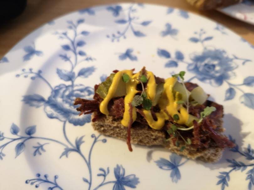 Pastrami and mustard open sandwich on a plate