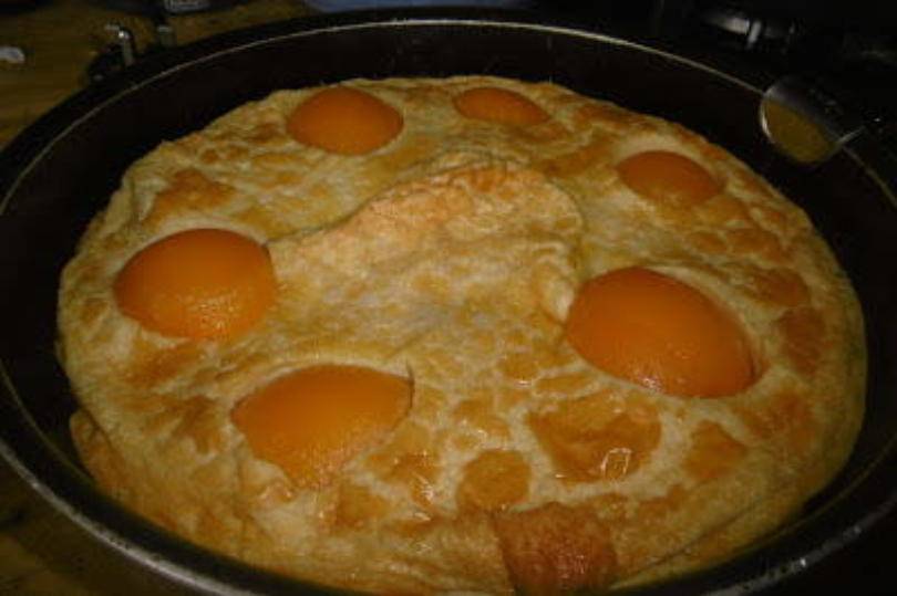 Peach Dutch Baby Pancakes in a pan