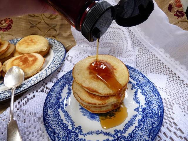 Yukon flapjacks or sourdough pancakes on a plate with syrup being poured over them