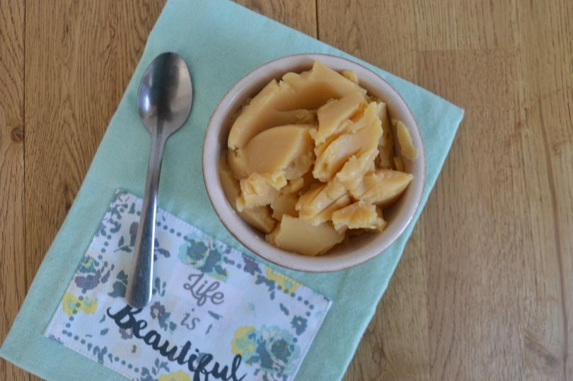 Pease pudding in a bowl on a green cloth with a spoon next to it