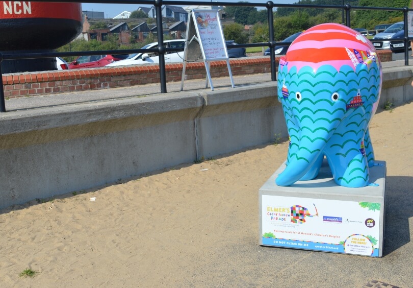 Beyond the sea elmer on the fish quay. He is blue with a red top
