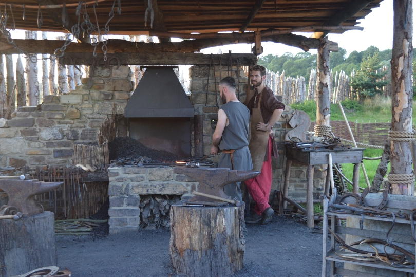 Two blacksmiths beside a forge in a viking hut at the viking village