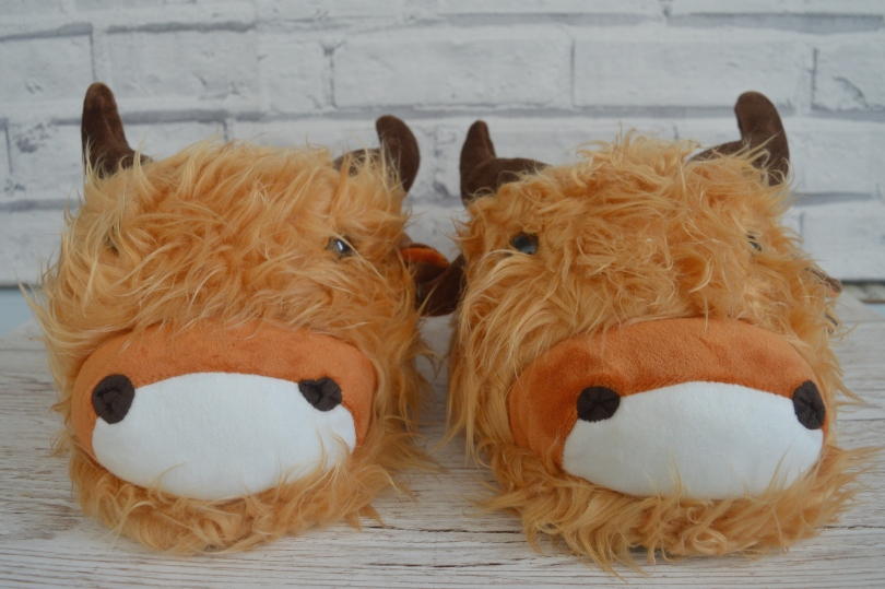 A pair of slippers that look like Highland cows