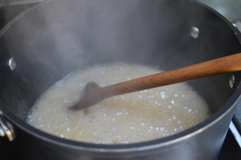 Crab apple juice with sugar and lemon simmering in a pan