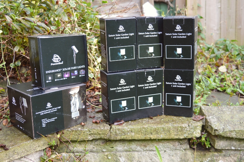 A selection of different types of solar lighting from PowerBee in boxes on a wall