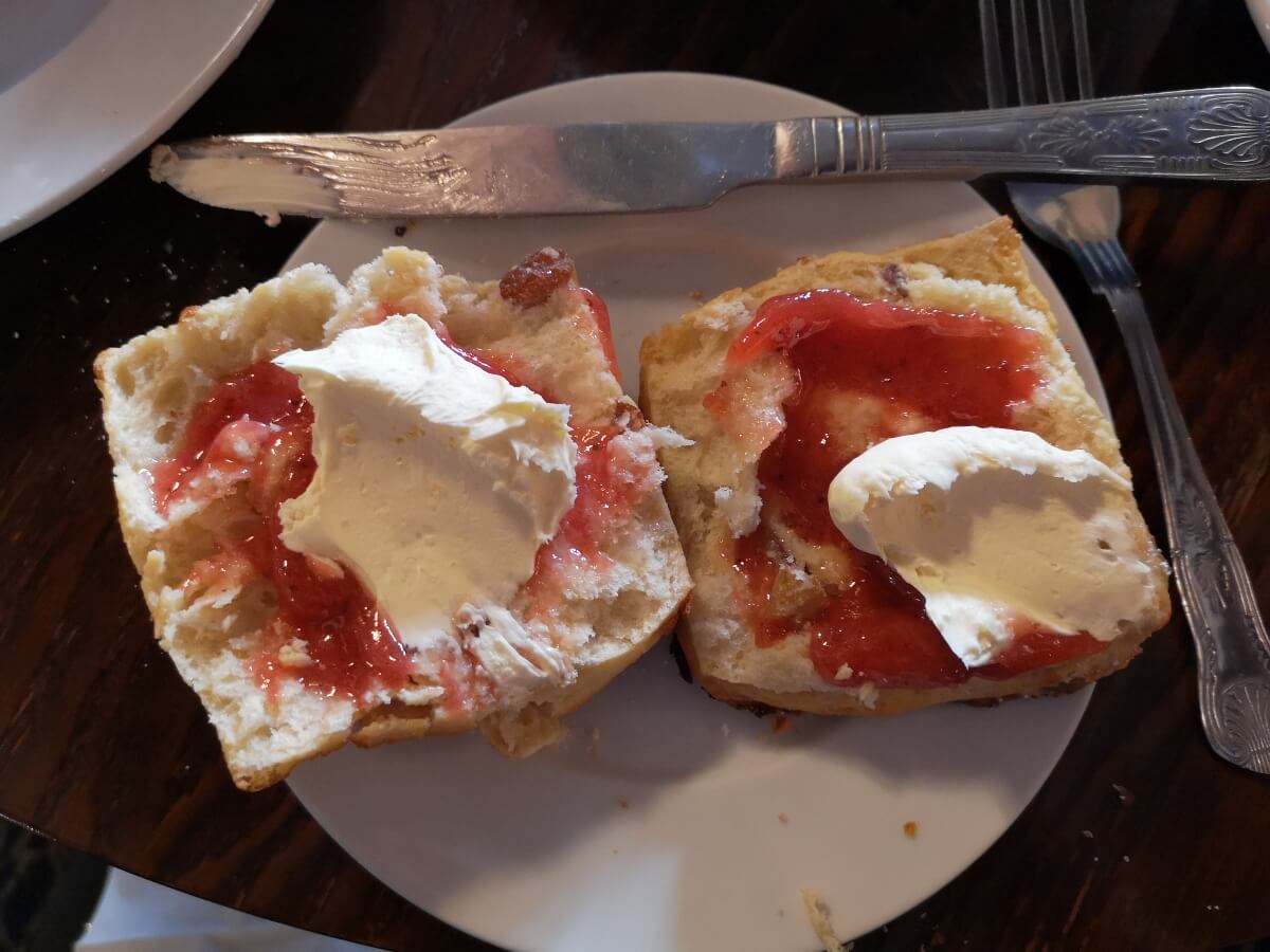 scones cut open on a plate with cream and jam on top