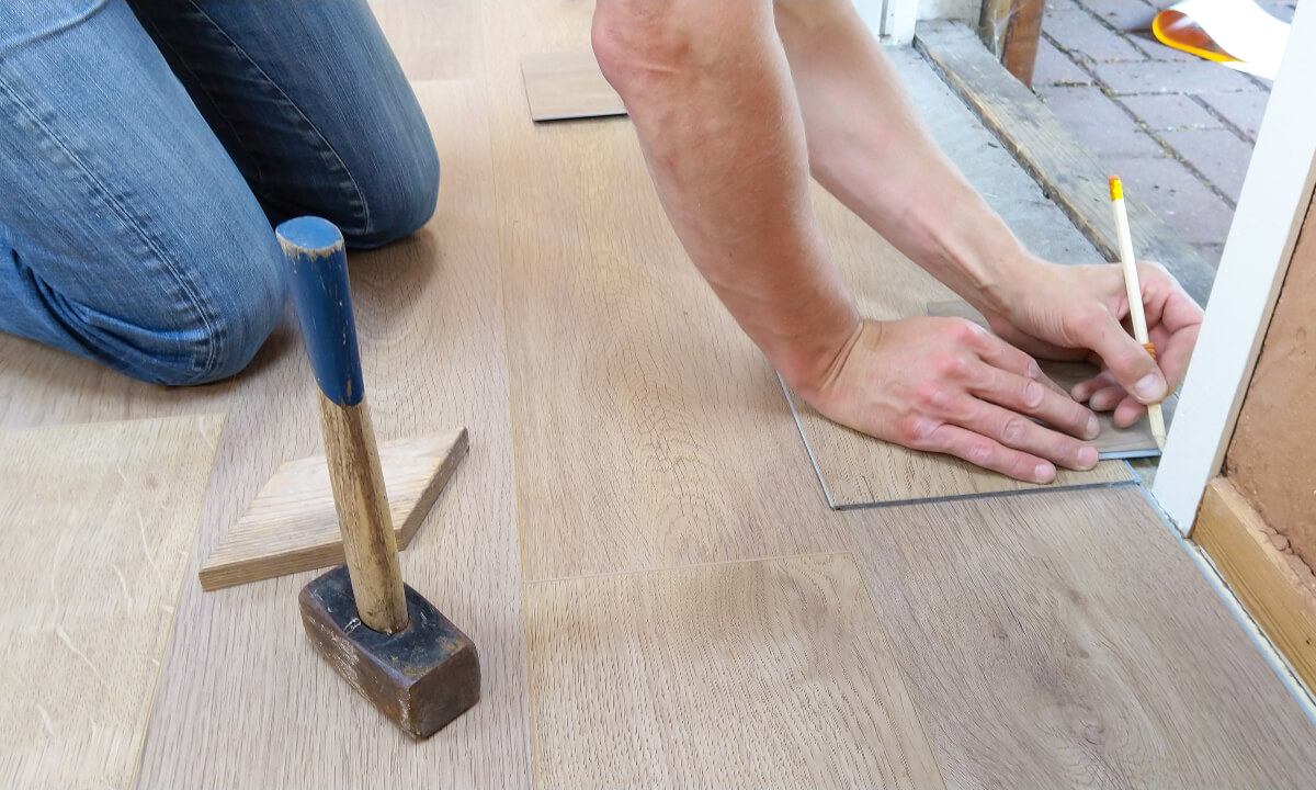 Person measuring floorboards
