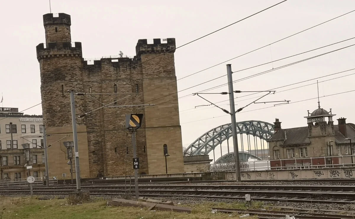Newcastle Castle beside the railway tracks with the Tyne Bridge visible in the background