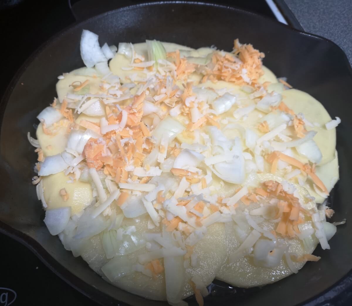 Adding grated cheese between potato layers for Pan Haggerty