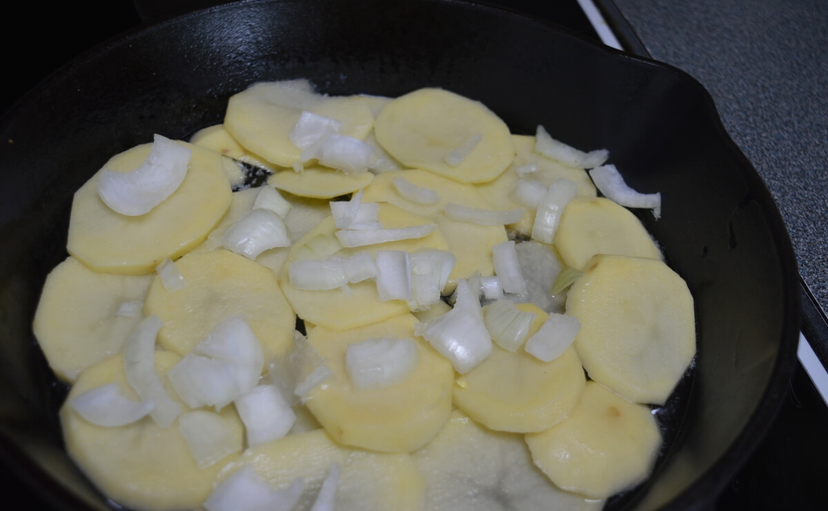 Layering sliced potatoes and onions for Pan Haggerty
