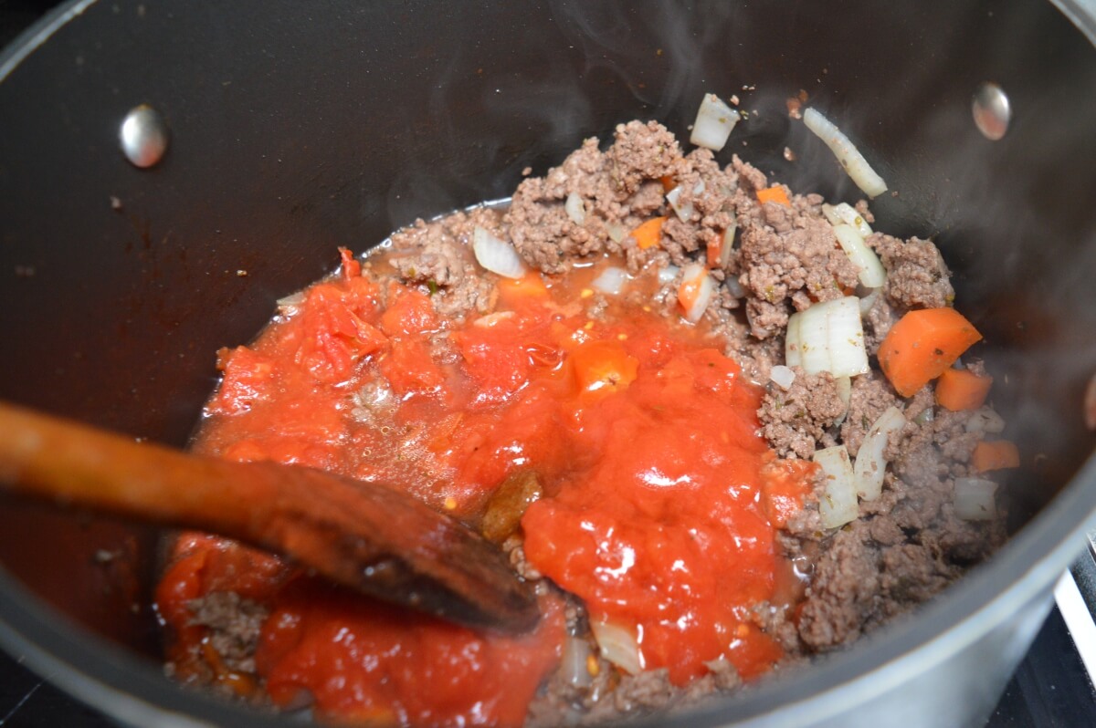 Adding chopped tomatoes to the mince filling