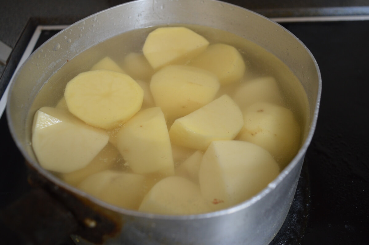 Potatoes boiling in a saucepan for cottage pie topping