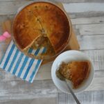 A bowl of rhubarb dessert with a serving dish beside it