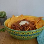 Simple beef nachos in a bowl with sour cream