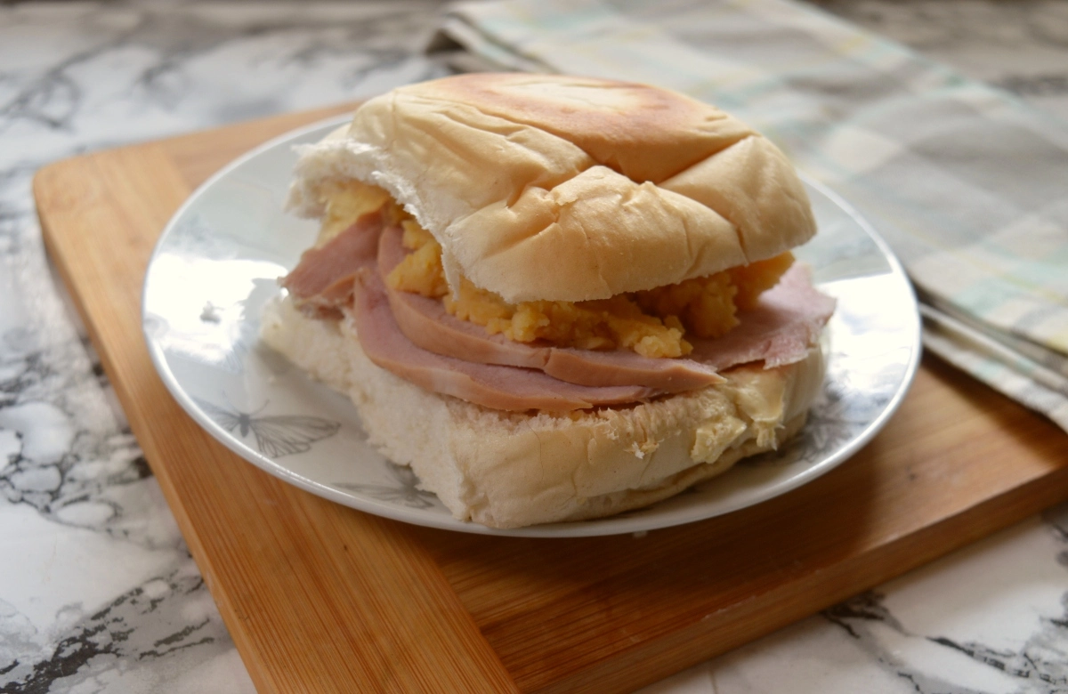 Ham and pease pudding in a stottie on a plate on a table