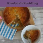 Rhubarb pudding on a table in a dish with the serving dish beside it