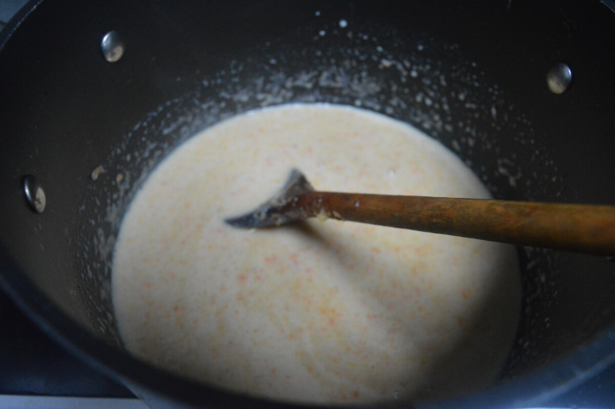 soup cooking in a pan with a wooden spoon