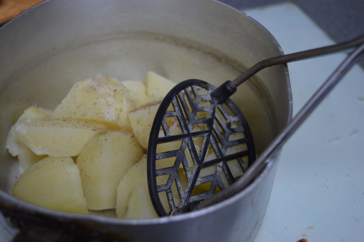 Potatoes in a pan being mashed