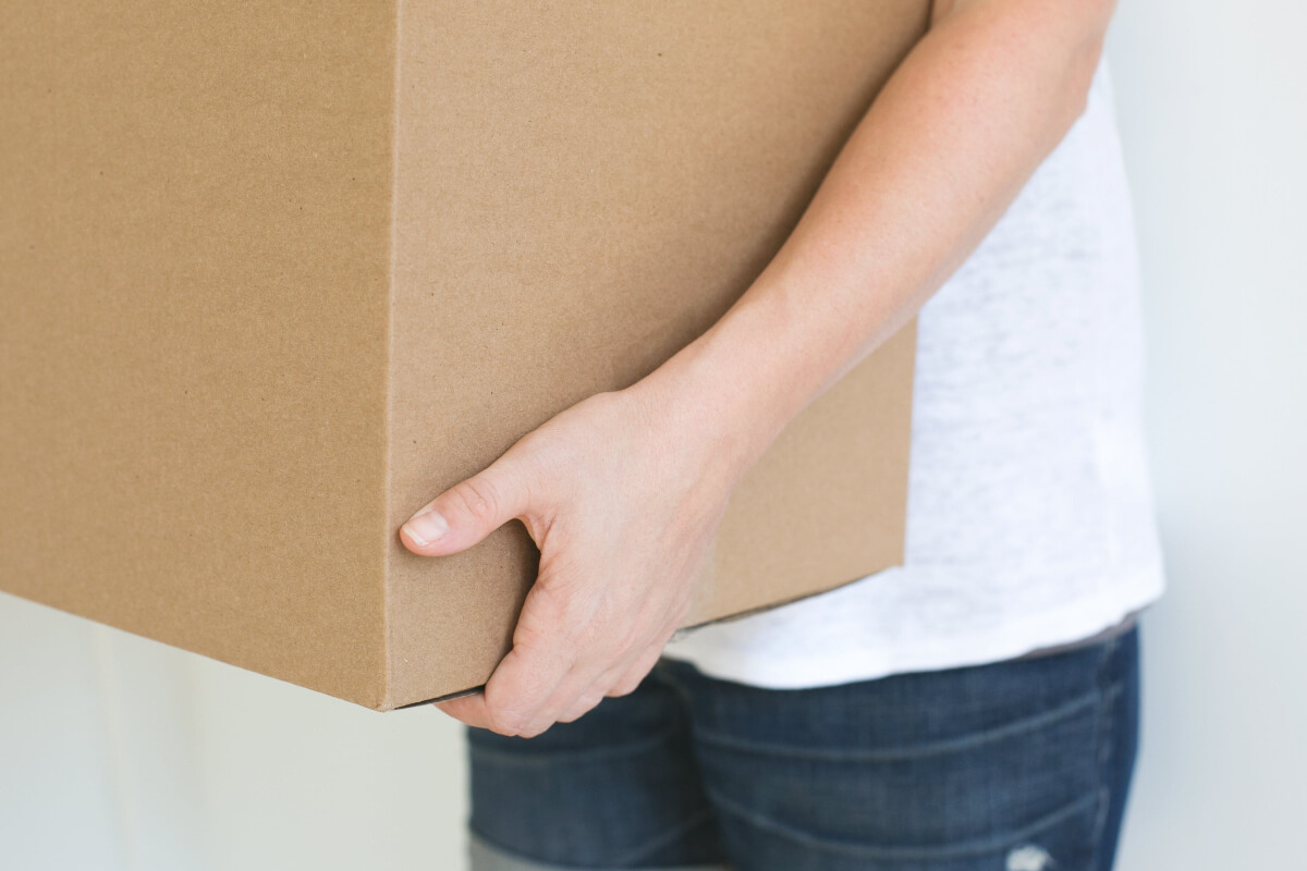 Person holding a cardboard box