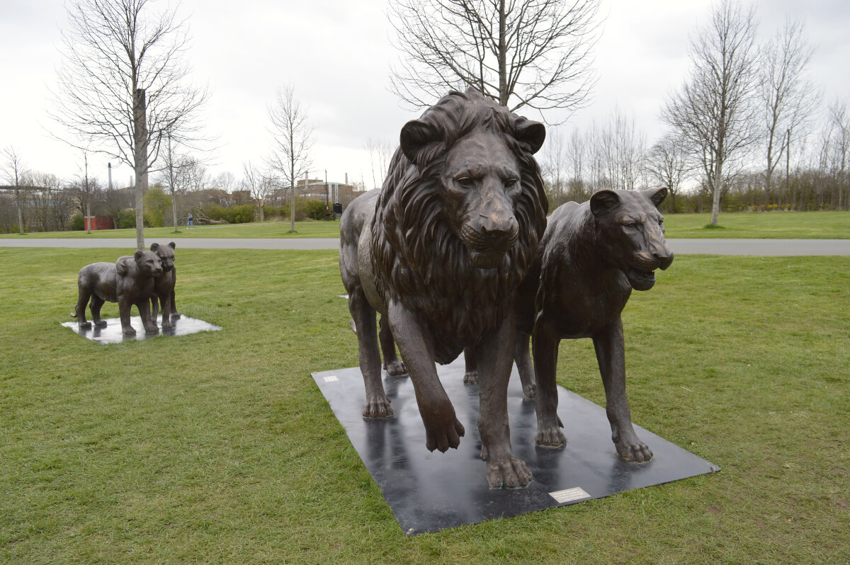 statue of amale and female lion walking together