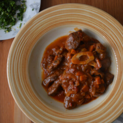 beef osso buco on a yellow plate