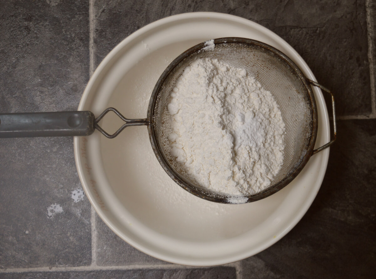 Flour being sifted into a bowl