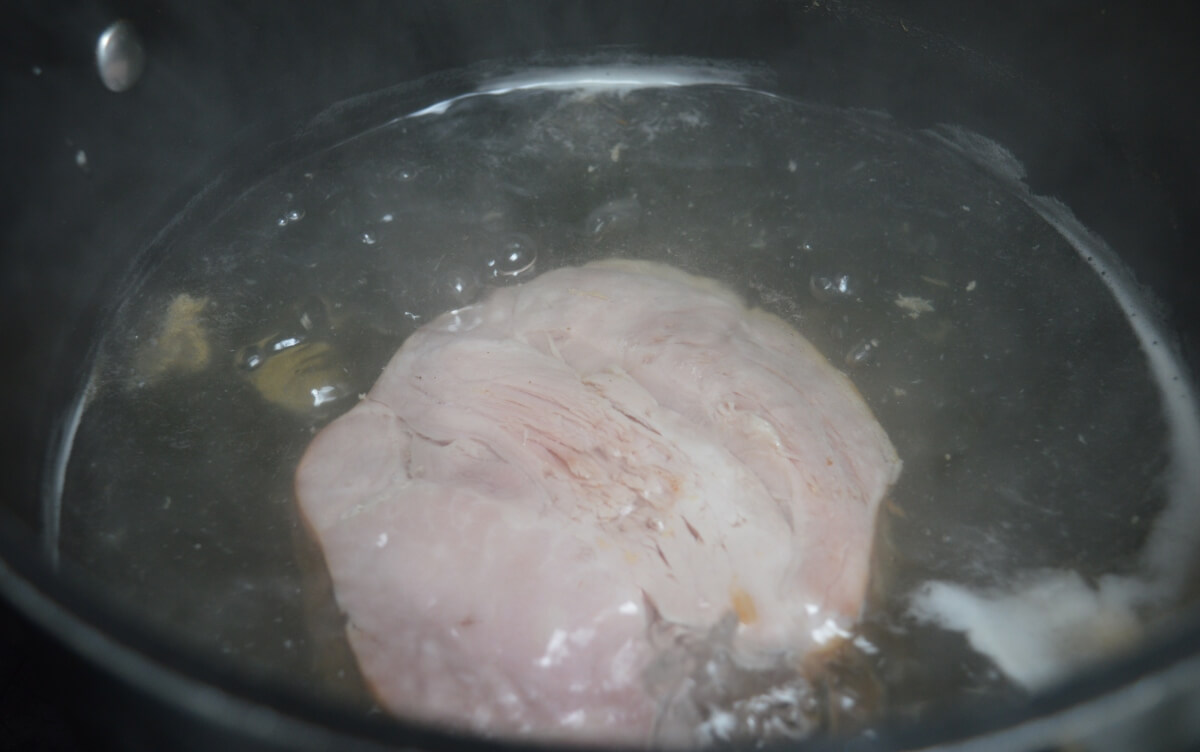 Foam rising to the surface while the ham stock comes to the boil.