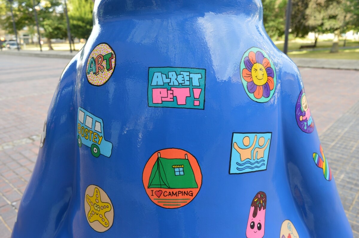 Colourful hand-painted badges on Golden Peter Rabbit's blue jacket