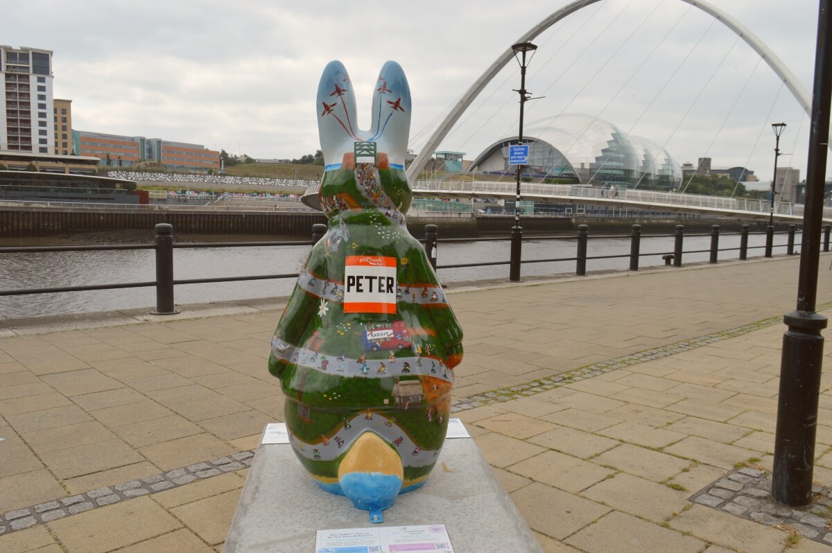 Back of The Great North Bun Peter Rabbit sculpture with the Gateshead Millennium Bridge across the River Tyne.