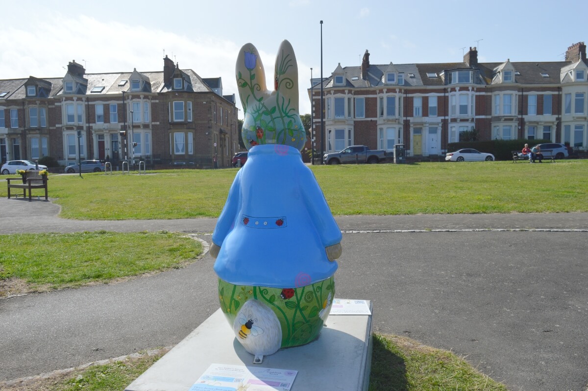 Back of Hoppy Days Peter Rabbit sculpture showing wildflowers, ladybirds and a bee in Cullercoats