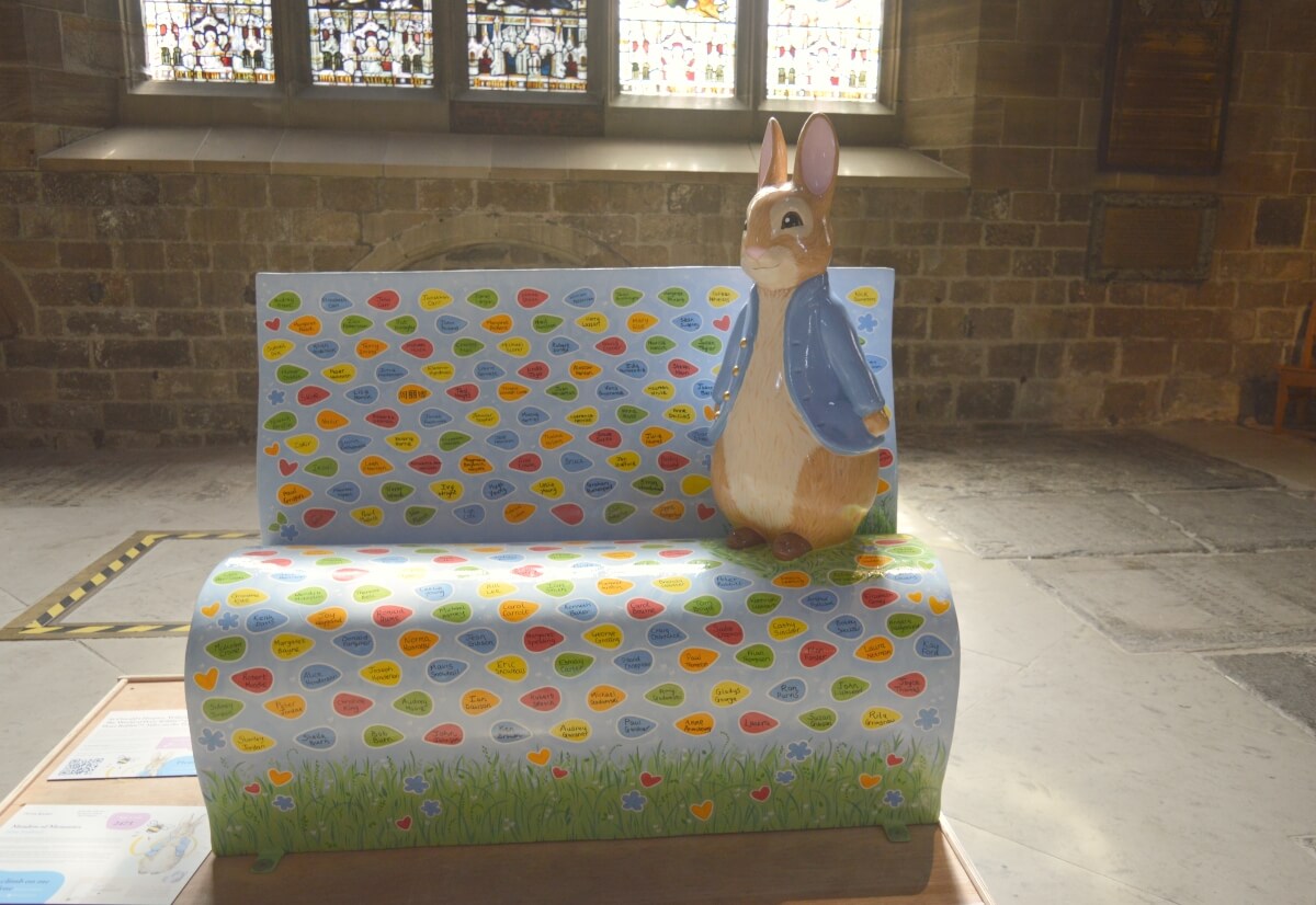 Meadow of Memories Peter Rabbit sculpture on a memorial bench inside Newcastle Cathedral