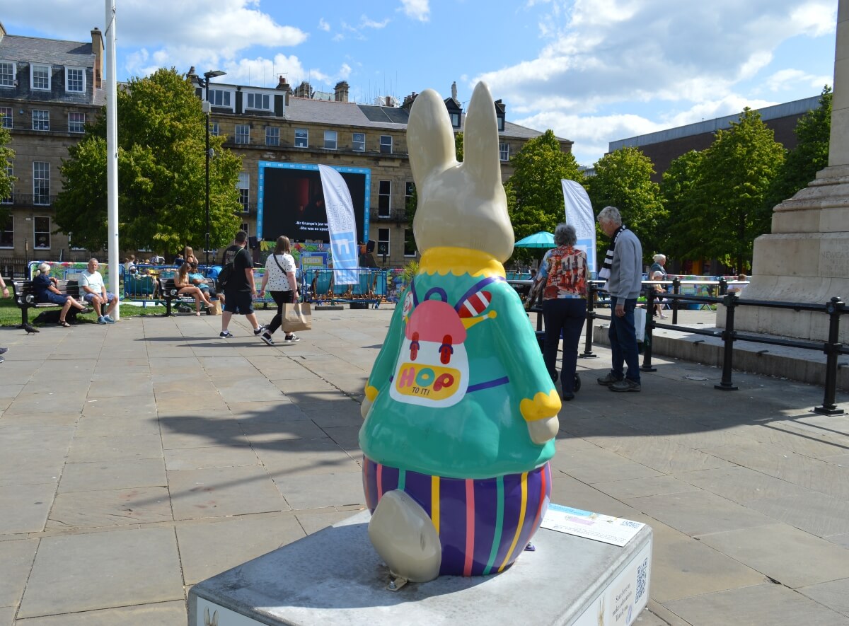 Back of Peter Hoppings showing his backpack and striped stick of rock in Newcastle