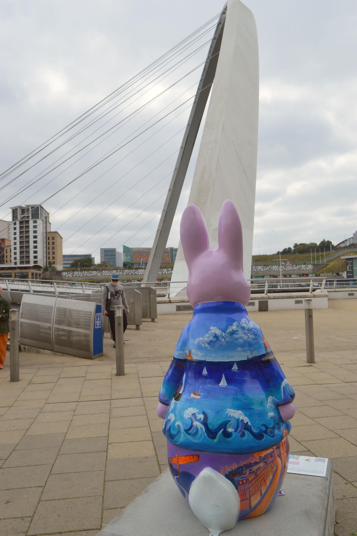 Back of Tyne-tastic Peter sculpture with the Gateshead Millennium Bridge behind it on Newcastle Quayside.